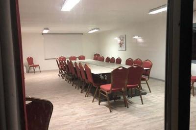 Rondin de bois gravé ’Chantal’ avec des cœurs, posé sur une serviette blanche avec une branche d'olivier.