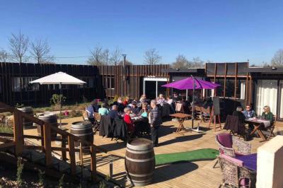 Rondin de bois gravé ’Chantal’ avec des cœurs, posé sur une serviette blanche avec une branche d'olivier.