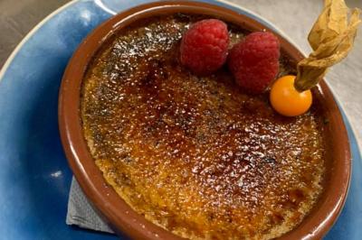 Rondin de bois gravé ’Chantal’ avec des cœurs, posé sur une serviette blanche avec une branche d'olivier.