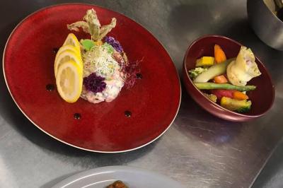 Rondin de bois gravé ’Chantal’ avec des cœurs, posé sur une serviette blanche avec une branche d'olivier.