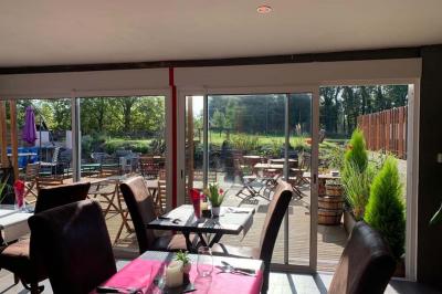 Rondin de bois gravé ’Chantal’ avec des cœurs, posé sur une serviette blanche avec une branche d'olivier.