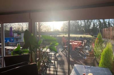 Rondin de bois gravé ’Chantal’ avec des cœurs, posé sur une serviette blanche avec une branche d'olivier.