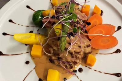 Rondin de bois gravé ’Chantal’ avec des cœurs, posé sur une serviette blanche avec une branche d'olivier.