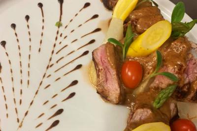 Rondin de bois gravé ’Chantal’ avec des cœurs, posé sur une serviette blanche avec une branche d'olivier.