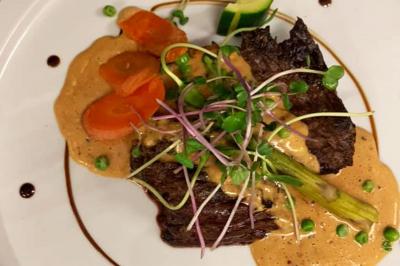 Rondin de bois gravé ’Chantal’ avec des cœurs, posé sur une serviette blanche avec une branche d'olivier.