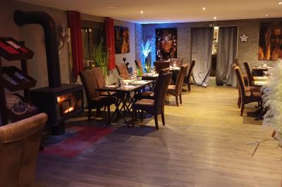 Table dressée en extérieur avec nappes blanches, fleurs en centre de table, parasols roses et verdure en arrière-plan.