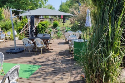 Gâteau rectangulaire décoré de fruits rouges et de cœurs en sucre, posé sur une table en bois.