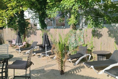 Gâteau rectangulaire décoré de fruits rouges et de cœurs en sucre, posé sur une table en bois.