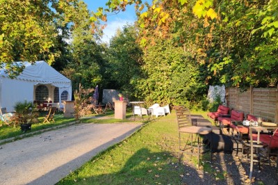 Gâteau rectangulaire décoré de fruits rouges et de cœurs en sucre, posé sur une table en bois.