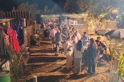 Gâteau rectangulaire décoré de fruits rouges et de cœurs en sucre, posé sur une table en bois.