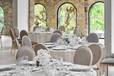 Jardin éclairé de nuit avec piscine, terrasse en pierre et bâtiments entourés de végétation.