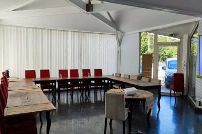 Jardin verdoyant avec pelouse, arbres et buissons, entourant une petite clairière circulaire en béton.
