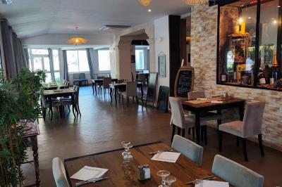 Jardin verdoyant avec pelouse, arbres et buissons, entourant une petite clairière circulaire en béton.