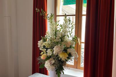 Cour intérieure aménagée avec des poufs colorés, des tables en bois et des guirlandes lumineuses suspendues.