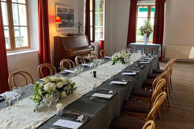 Cour intérieure aménagée avec des poufs colorés, des tables en bois et des guirlandes lumineuses suspendues.