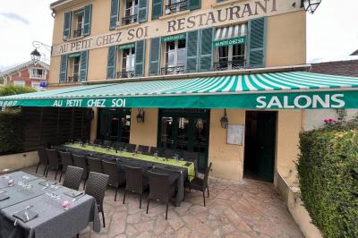 Cour intérieure aménagée avec des poufs colorés, des tables en bois et des guirlandes lumineuses suspendues.