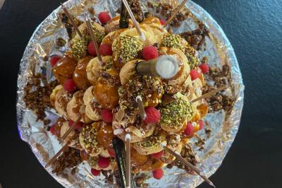 Cour intérieure aménagée avec des poufs colorés, des tables en bois et des guirlandes lumineuses suspendues.