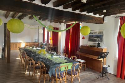 Cour intérieure aménagée avec des poufs colorés, des tables en bois et des guirlandes lumineuses suspendues.