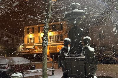 Cour intérieure aménagée avec des poufs colorés, des tables en bois et des guirlandes lumineuses suspendues.