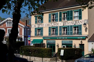 Cour intérieure aménagée avec des poufs colorés, des tables en bois et des guirlandes lumineuses suspendues.