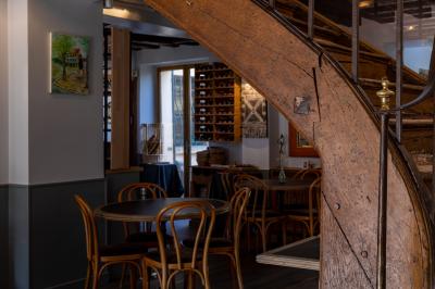 Cour intérieure aménagée avec des poufs colorés, des tables en bois et des guirlandes lumineuses suspendues.