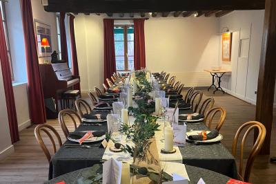 Cour intérieure aménagée avec des poufs colorés, des tables en bois et des guirlandes lumineuses suspendues.