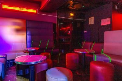 Façade noire d'une discothèque avec une enseigne dorée indiquant ’Rexy Paris Club/Discothèque’.