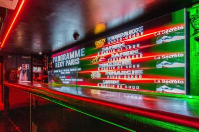 Façade noire d'une discothèque avec une enseigne dorée indiquant ’Rexy Paris Club/Discothèque’.