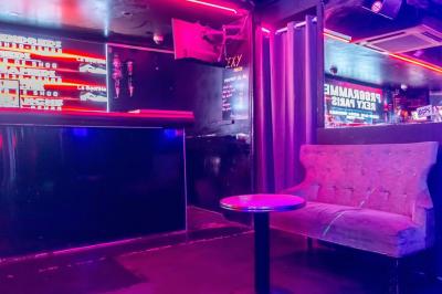 Façade noire d'une discothèque avec une enseigne dorée indiquant ’Rexy Paris Club/Discothèque’.