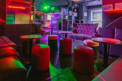 Façade noire d'une discothèque avec une enseigne dorée indiquant ’Rexy Paris Club/Discothèque’.