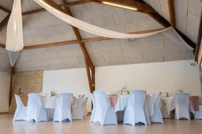 Un couple de mariés dans un jardin, la mariée tenant un bouquet de roses pastel au premier plan.