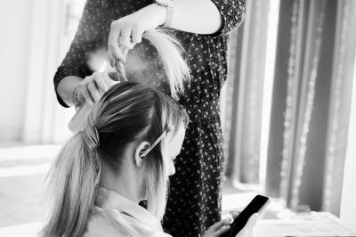 Un couple de mariés dans un jardin, la mariée tenant un bouquet de roses pastel au premier plan.