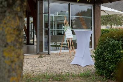 Un couple de mariés dans un jardin, la mariée tenant un bouquet de roses pastel au premier plan.