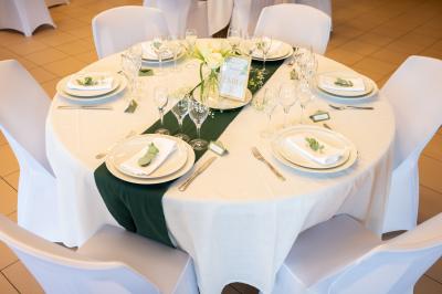 Un couple de mariés dans un jardin, la mariée tenant un bouquet de roses pastel au premier plan.