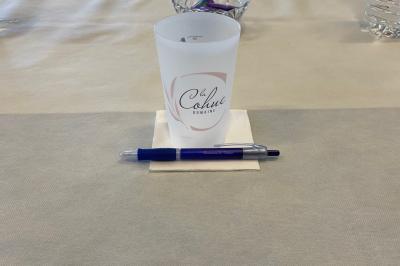 Salle de réunion lumineuse avec des chaises disposées en rangées face à un écran de projection et un tableau blanc.