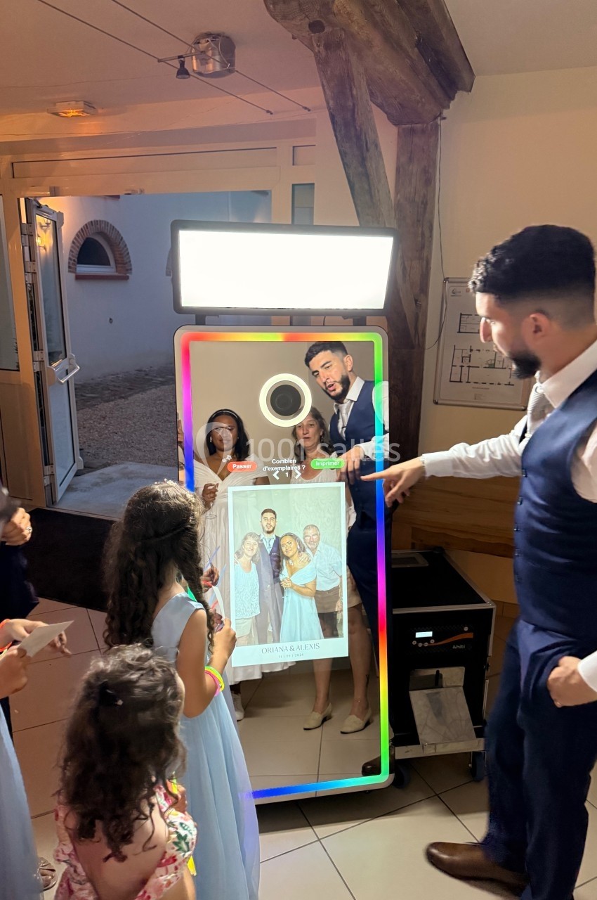 Un groupe de personnes utilise un miroir photobooth interactif lors d'un événement en intérieur.