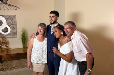 Salle de spectacle avec un public debout et assis, décorations festives et scène éclairée avec une présentation en cours.
