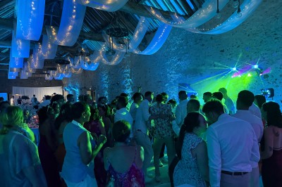 Salle de spectacle avec un public debout et assis, décorations festives et scène éclairée avec une présentation en cours.