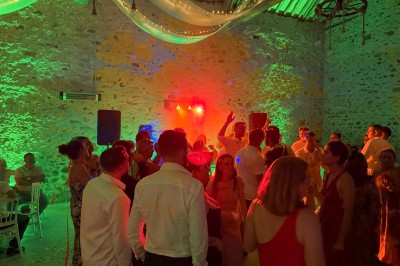 Salle de spectacle avec un public debout et assis, décorations festives et scène éclairée avec une présentation en cours.