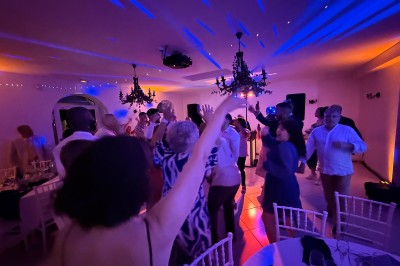 Salle de spectacle avec un public debout et assis, décorations festives et scène éclairée avec une présentation en cours.