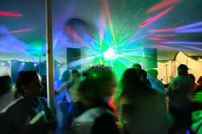 Poste de DJ éclairé en violet avec des haut-parleurs et des lumières dans une salle au décor classique.