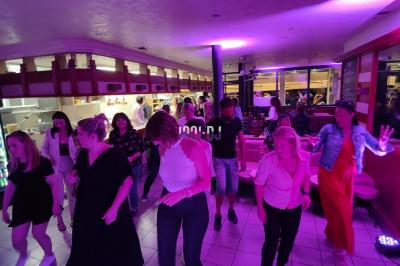 Poste de DJ éclairé en violet avec des haut-parleurs et des lumières dans une salle au décor classique.