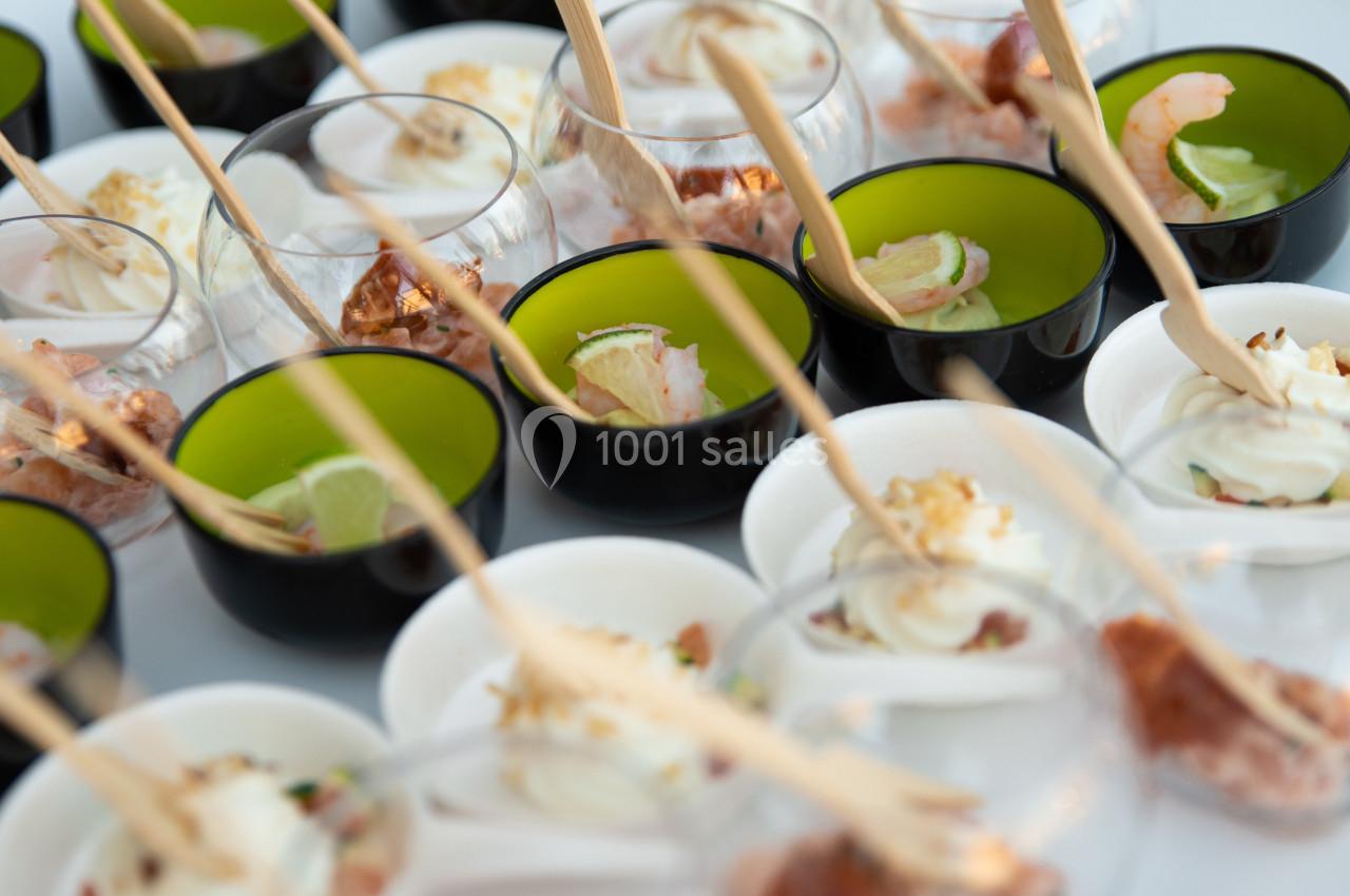 Assortiment de verrines colorées contenant des entrées variées, présentées avec des cuillères en bois.