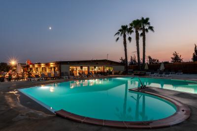 Structure de jeux colorée avec toboggans multiples, située sur un sol en gravier sous un ciel dégagé.