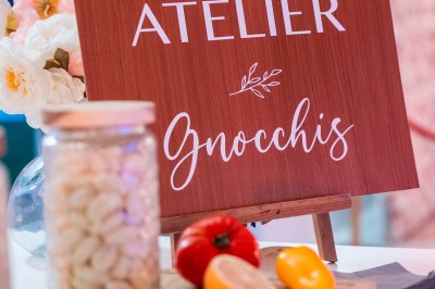 Une personne tranche un filet de saumon sur une planche en bois, avec des toasts préparés en premier plan.