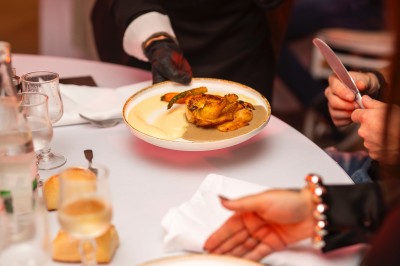 Une personne tranche un filet de saumon sur une planche en bois, avec des toasts préparés en premier plan.