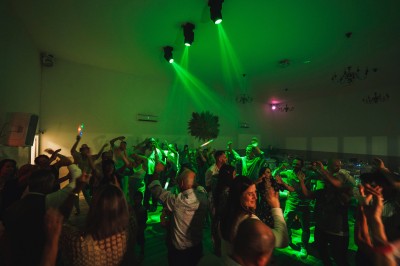Une personne tranche un filet de saumon sur une planche en bois, avec des toasts préparés en premier plan.