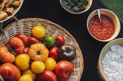 Une personne tranche un filet de saumon sur une planche en bois, avec des toasts préparés en premier plan.