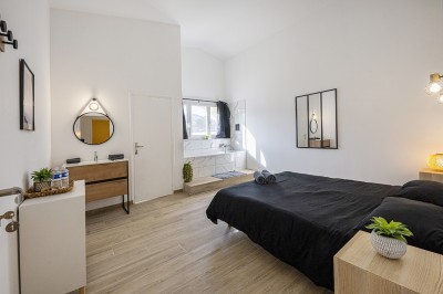 Une personne tranche un filet de saumon sur une planche en bois, avec des toasts préparés en premier plan.