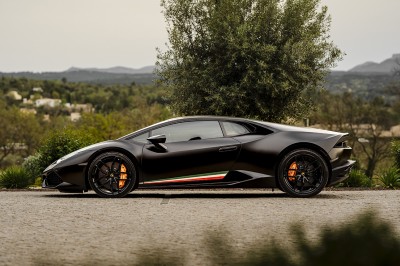 Une personne tranche un filet de saumon sur une planche en bois, avec des toasts préparés en premier plan.